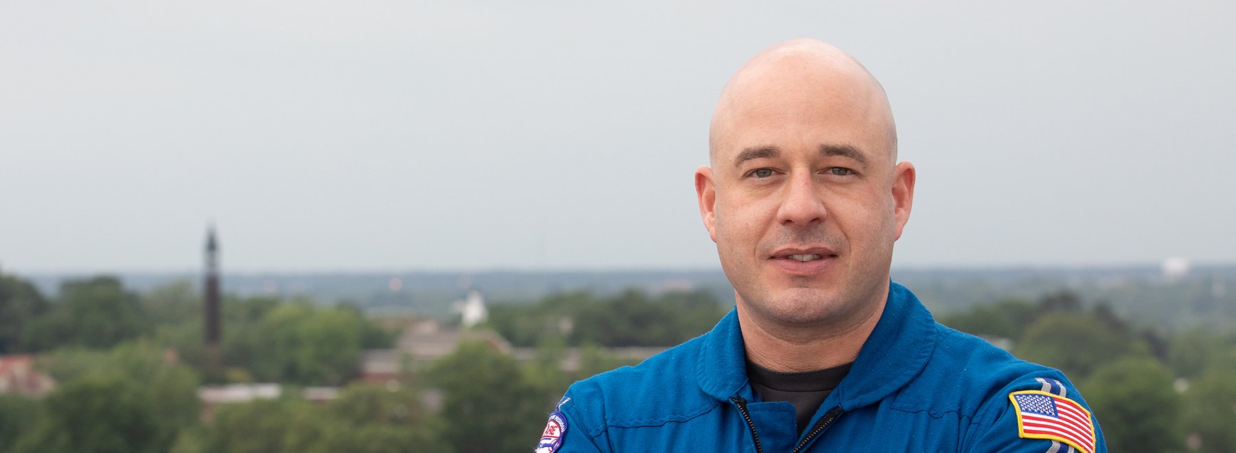 Male aircare pilot and masters student poses on the helipad.